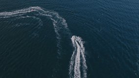 Aerial footage of two speedboats slicing through deep blue ocean, leaving vivid white arcs in their wake. The scene captures the thrill of coastal recreation with dramatic aquatic motion. - Powered by Shutterstock - Get 15% off with code: PIKWIZARD15