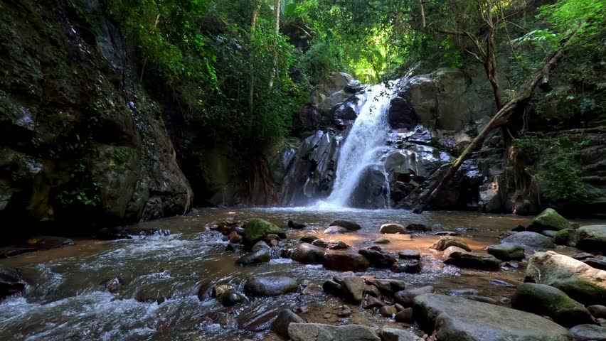 Ambient motion of a waterfall hidden in a lush forest in a hiking trail in Khao Sok National Park in Surat Thani, Thailand