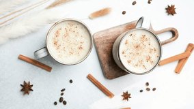 Two cups warm beverage with cinnamon spice, coffee beans, star anise and cinnamon sticks on table. - Powered by Shutterstock - Get 15% off with code: PIKWIZARD15