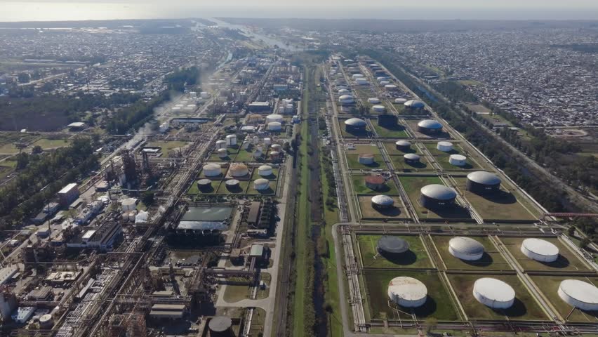 Daytime drone shot of oil refinery and natural gas facility near neighborhood
