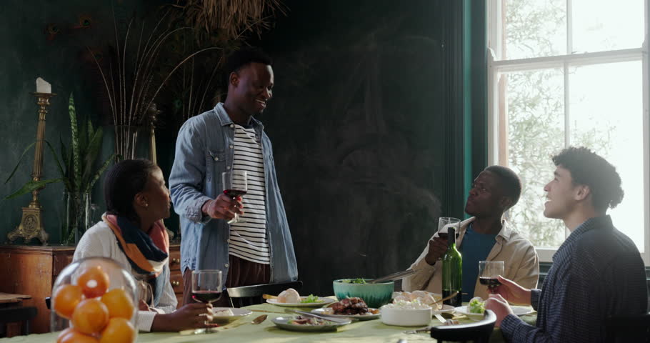 Man, people and cheers with red wine at house for celebration, dinner party and reunion. Group, friends and toast with alcohol for good news, social gathering and happy hour in dining room for event