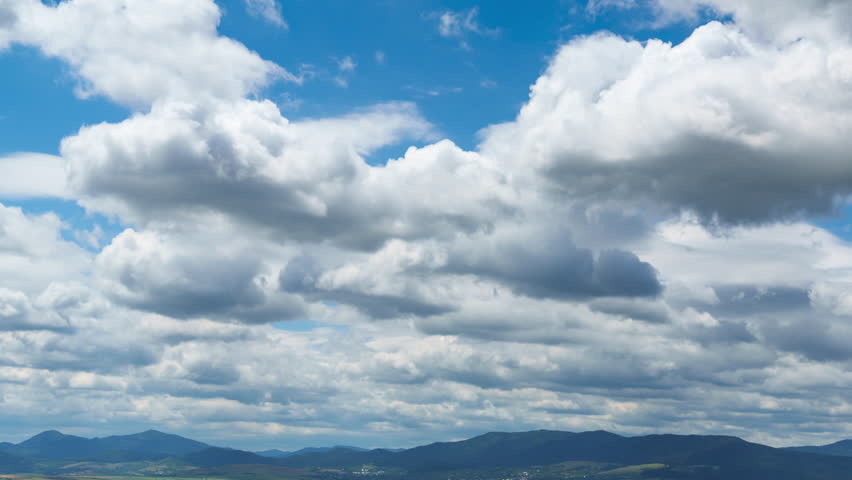 beautiful spring landscape with white clouds, timelapse, fields and village, Carpathian mountains in the distance
