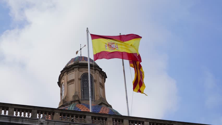 The Spanish flag and the Catalan flag are flying on the administrative building. High quality 4k footage