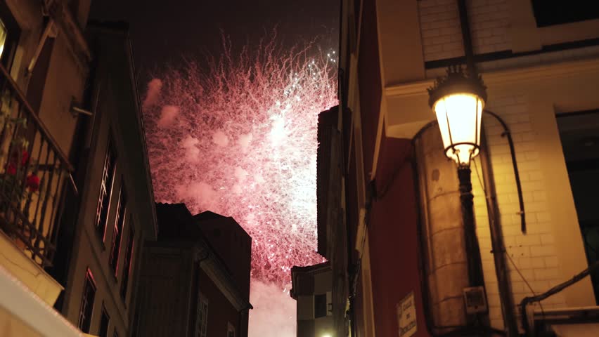 Festive fireworks light up the night sky above charming European streets, New Year celebration, Christmas holiday, old town architecture, night cityscape, magical atmosphere, fiesta, festival