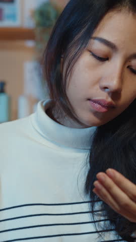 Vertical Screen : Sick young Asia woman holding pill glass of water take medicine sit on couch at home night. Girl taking medicine after doctor order, quarantine at house, social distancing concept.