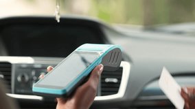 African woman making contactless credit card payment for transport fare using POS terminal inside a car. - Powered by Shutterstock - Get 15% off with code: PIKWIZARD15