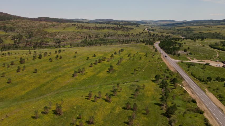 Stunning aerial view of rolling green hills and winding road in Wyoming