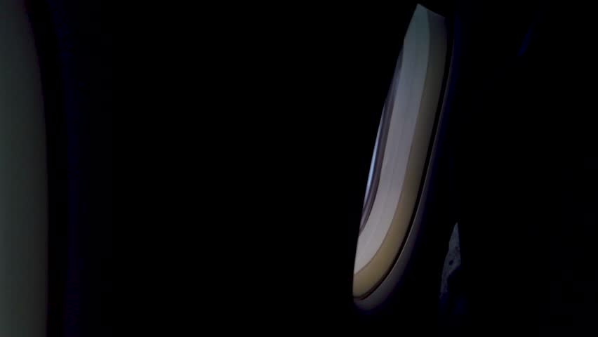 POV airplane wing view from passenger window flying above clouds on a slightly cloudy morning sky during flight journey