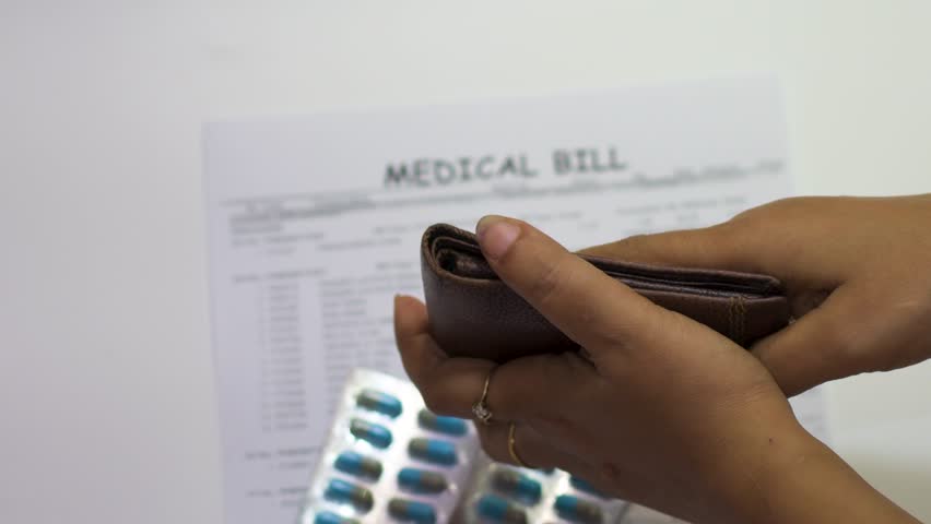 A person shows an empty wallet beside a medical bill and pills, symbolizing the rising healthcare costs and financial burden faced by middle-class people.