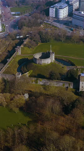 4K vertical drone video of Cardiff Castle’s Norman motte and bailey keep, ringed by a moat beside Bute Park and the city - mobile ready footage of Wales’ capital landmark ideal for social media reels.