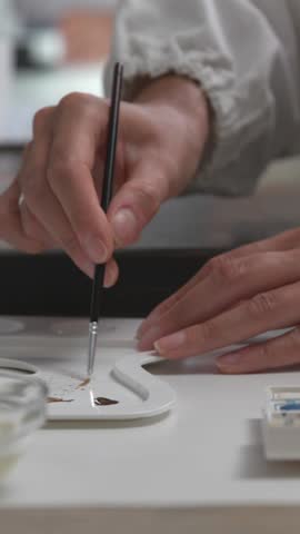 Expert painting conservator restoring an artwork using a thin brush, cultural heritage and painting conservation concept