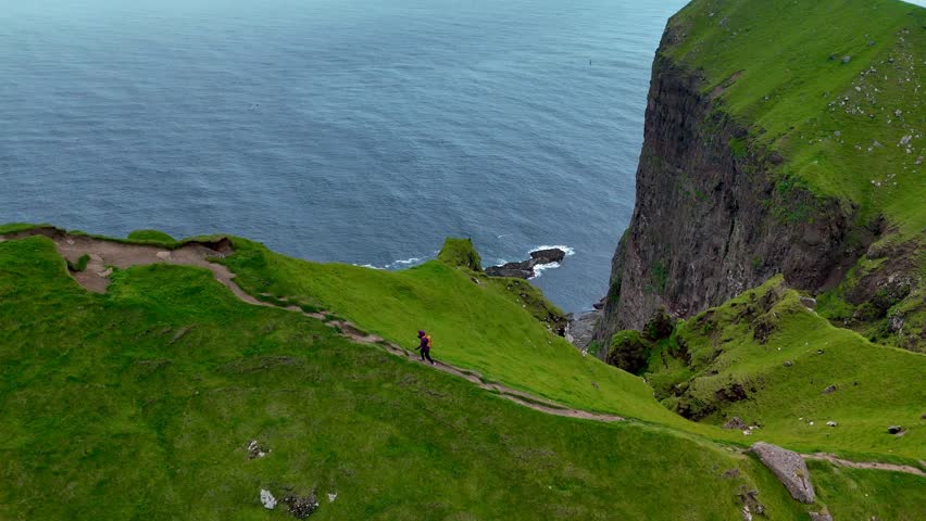 Experience stunning green landscapes and dramatic sea cliffs on Kalsoy Island in the Faroe Islands. Enjoy serene hiking trails that lead to breathtaking ocean views and rugged hills.