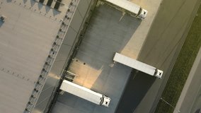 Aerial view of a logistics hub with three trucks at loading docks, showcasing efficient freight transportation in a modern warehouse setting. - Powered by Shutterstock - Get 15% off with code: PIKWIZARD15