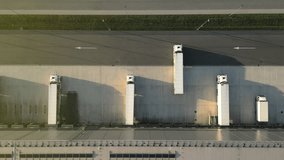 Aerial view of a modern distribution warehouse with loading docks. White trucks are parked and maneuvering, showcasing efficient freight logistics and organized cargo handling. - Powered by Shutterstock - Get 15% off with code: PIKWIZARD15