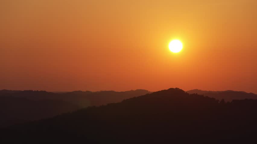 A time-lapse of an orange summer sunset over the silhouettes of the mountains of Kentucky.