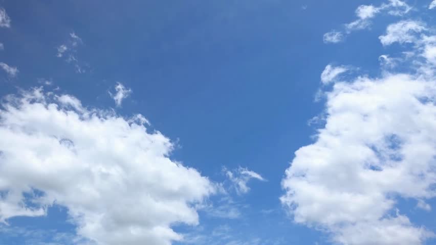 Beautiful blue sky background with fluffy white clouds drifting around