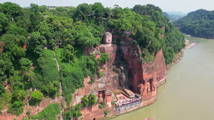 Leshan, China: Aerial orbit drone footage of the famous Leshan giant Buddha stone statue  at the confluence of the Min River and Dadu River in Sichuan in China.