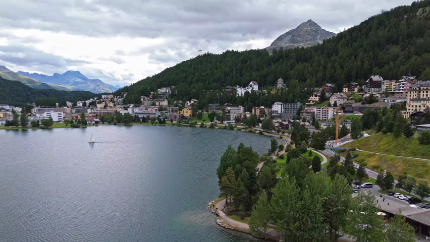 Serene lake view in St. Moritz, surrounded by lush mountains
