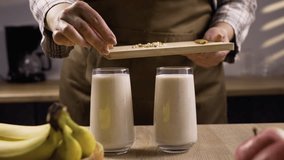 Woman cooking Healthy vegan smoothie with bananas and milk decorated with chopped almond. - Powered by Shutterstock - Get 15% off with code: PIKWIZARD15