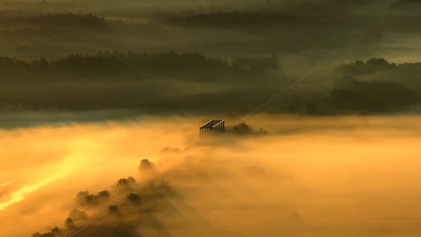 Aerial view of misty bridge over Nida River in warm light, rural Poland