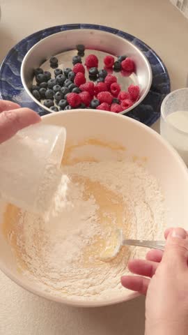 Anonymous mixing pancake batter ingredients in bowl. Calories, breakfast and cooking at home in kitchen.