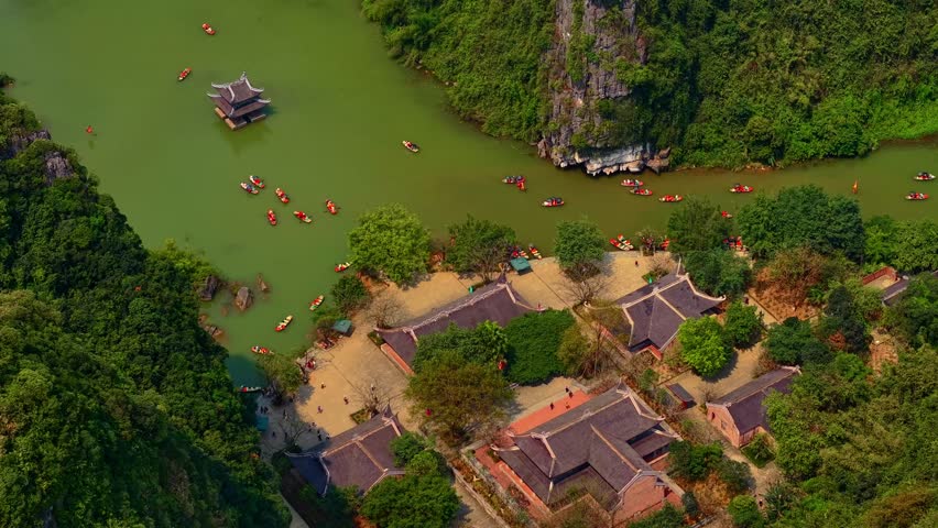 Travel concept Hanoi Vietnam, Ninh Binh with pagoda and limestone mountains at sunset.