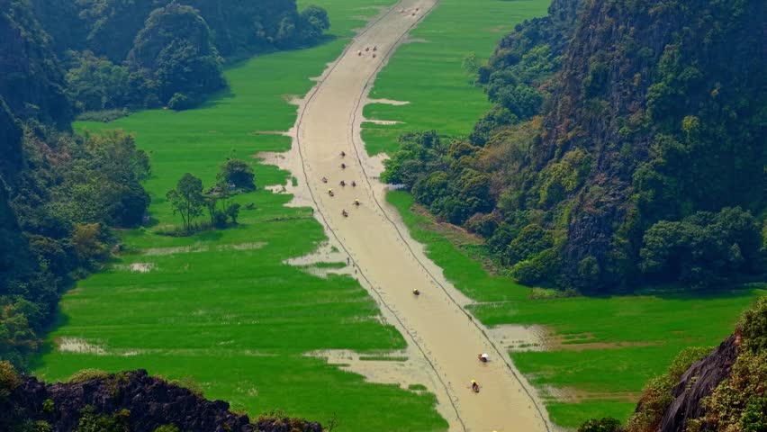 Scenic landscape of Ninh Binh, Vietnam, stunning mountains and tranquil river at sunset.