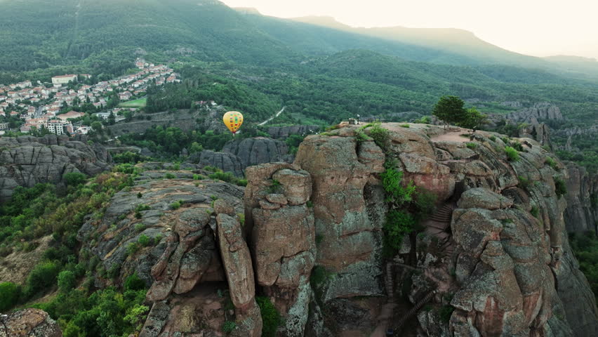 Stunning drone Belogradchik Rocks Bulgaria at sunrise showcasing unique rock formations hot air balloon flight green hills summer journey inspiring landscape tourism promotion aerial adventure