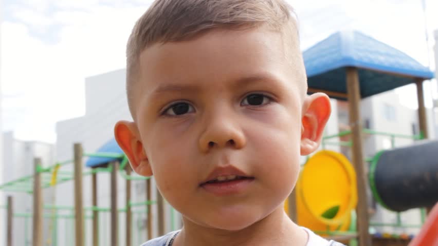 A little Colombian elementary school boy wearing overalls has fun in a park in Neiva, Huila, Colombia. Concept of childhood and fun