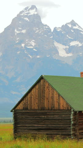 Imagine a picturesque wooden cabin set against a stunning mountain backdrop, surrounded by vibrant greenery. This setting is ideal for nature and landscape photography enthusiasts