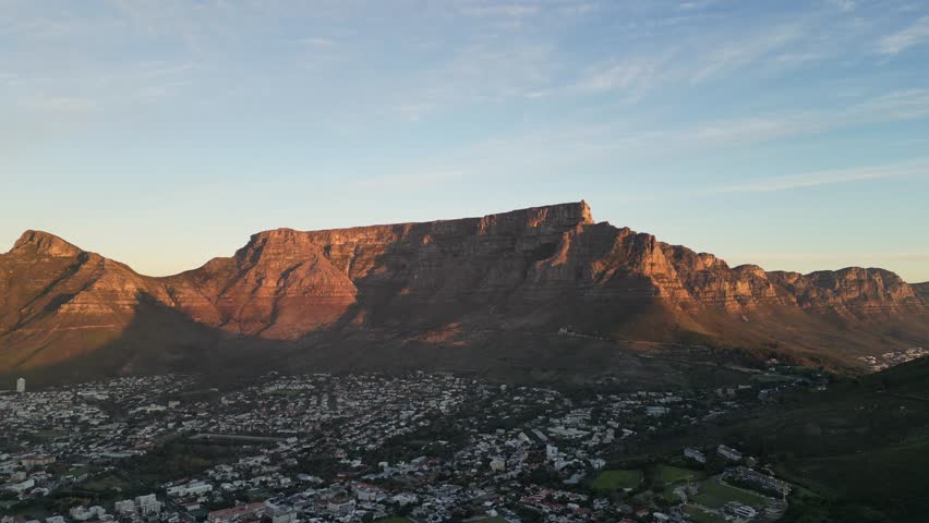 Smooth forward-motion drone footage highlighting the iconic Table Mountain in Cape Town, South Africa, under clear skies. The clip captures the natural beauty and scale of this world-famous landmark.