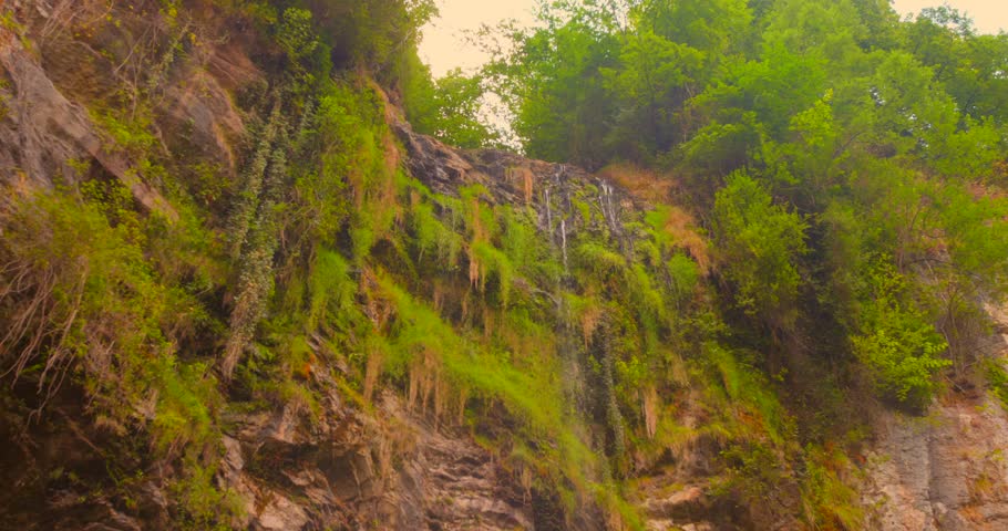 Small dwindling waterfall and stream, symbolizing the visible effects of climate change and drought on nature's delicate water resources.