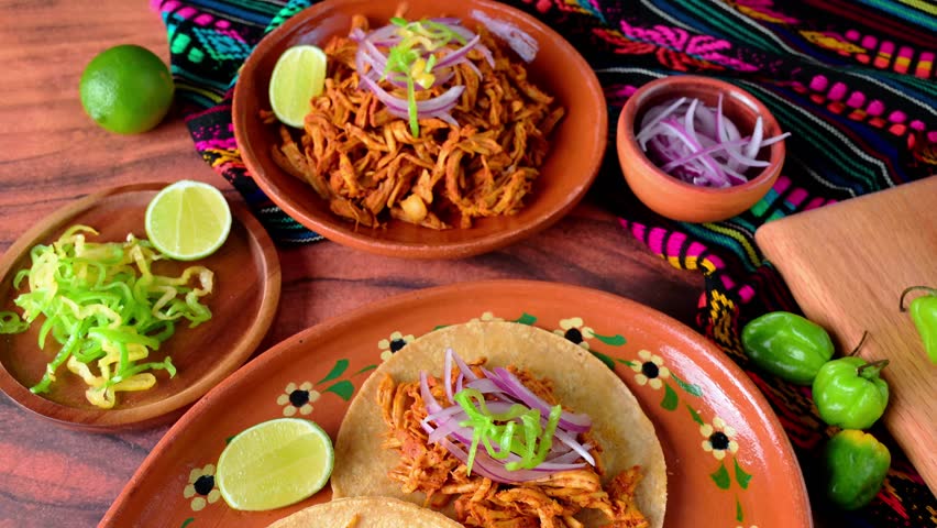 Colorful plate of mexican food, cochinita pibil and tacos, slow-motion