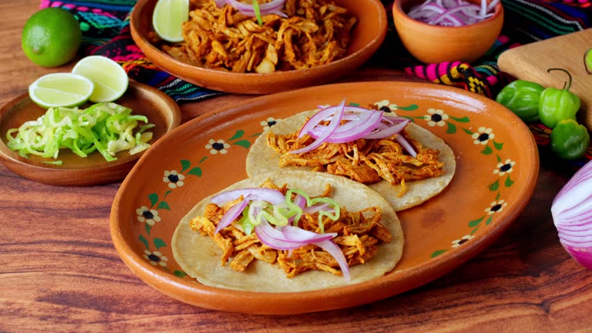Mexican food, cochinita pibil, putting on top habanero pepper on tacos