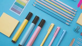 Bright colored pens and pencils arranged neatly on a blue background with stationery items. - Powered by Shutterstock - Get 15% off with code: PIKWIZARD15