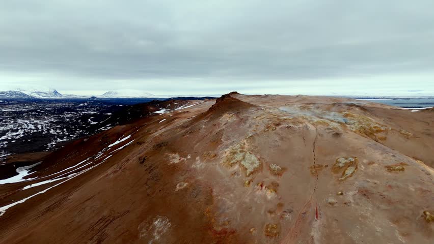Drone footage of the sulfuric geothermal fields at Námafjall Hverir in northern Iceland. filled with steaming vents, bubbling mud pots, and vivid yellow sulfur deposits