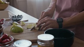 Tilt up shot of young Asian man preparing healthy breakfast from fresh fruits in cozy home kitchen - Powered by Shutterstock - Get 15% off with code: PIKWIZARD15