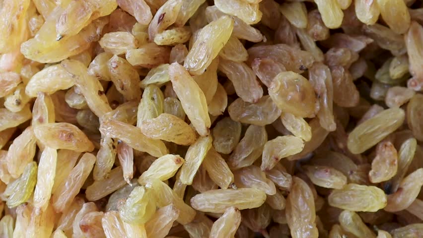 Golden raisins close up rustic video of dried fruit abundance in natural warm colors