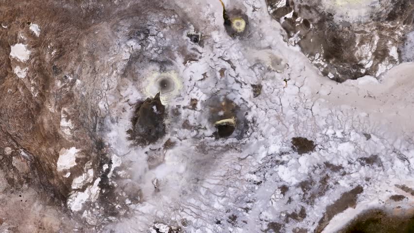Splashing hot spring field in Iceland. Aerial top down. Boiling water of volcano. Descend shot.