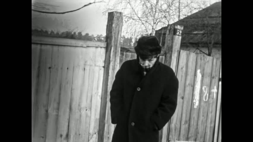 Man introverted in winter coat in abandoned outdoors. Depressed, cold, emotional closed, taciturn person. Vulnerability masculinity frustration feelings. Vintage film. Old archive. Archival retro