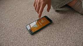 Handheld POV shot of young Asian man practicing meditation in lotus position using mobile phone with application for session in living room - Powered by Shutterstock - Get 15% off with code: PIKWIZARD15