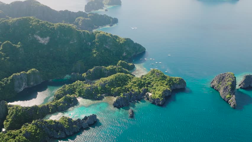 Surrounding cliffs form a protective embrace around the still waters of the lagoons with sun reflections. Miniloc Island. El Nido, Philippines. Palawan.