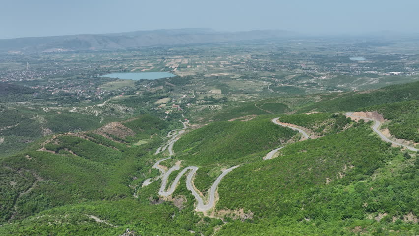 Winding Mountain Road Through Green Albanian Hills and Farmland Landscape