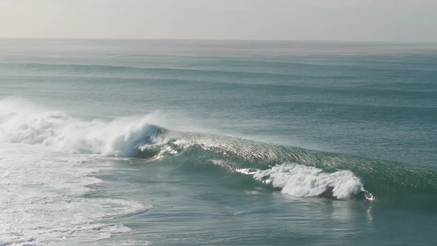 Aerial view of a powerful wave crashing near Nobbys Beach, its foamy crest contrasting with the deep turquoise ocean waters, Newcastle, New South Wales, Australia.