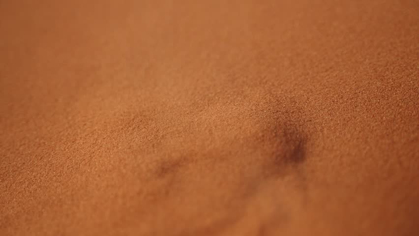 Desert sand rises in reverse slow motion, symbolizing time moving back