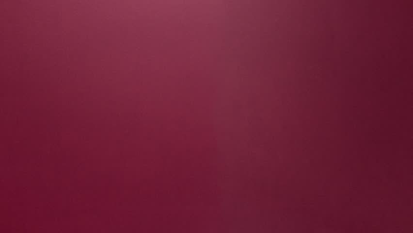 Festive silver glitter note taped with gold on a burgundy background for copy space