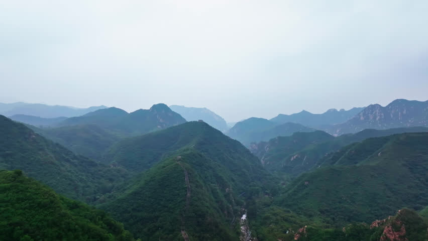 Aerial pull back revealing a watchtower in the mountains of Great Wall of China