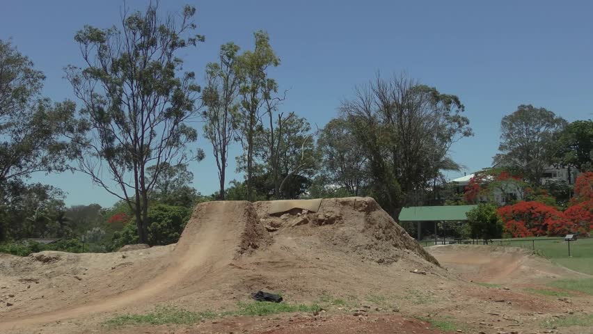 Dynamic 4K BMX footage of a superman trick over a dirt jump, shot from behind. Ideal for commercials, sports promos, or vlogs. 4K, 9s, model-released. License now!