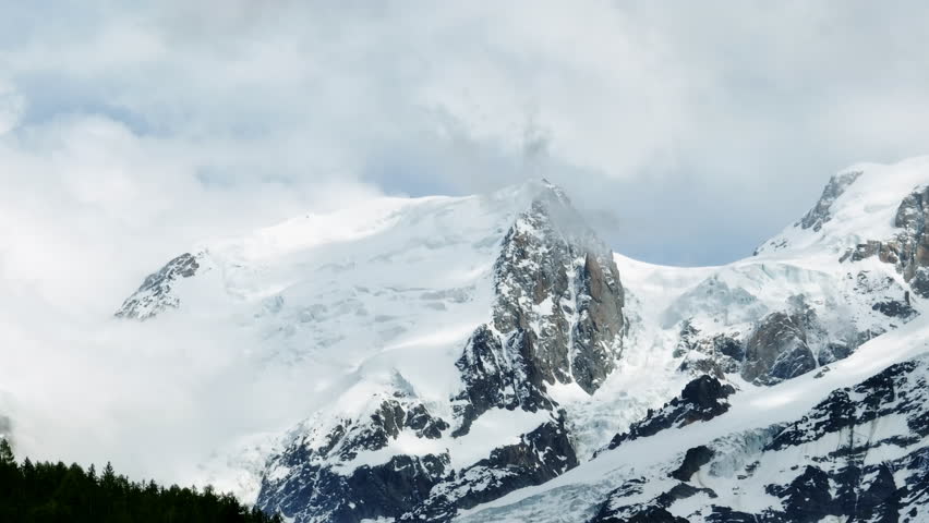 Aerial telezoom of snowy, rocky mountain peaks, surrounding Chamonix in France