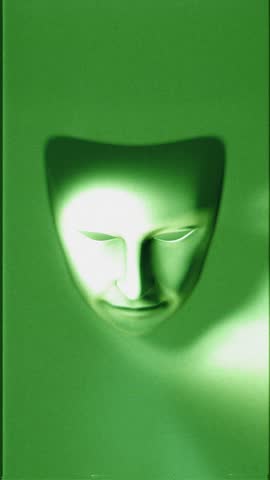 A theatrical style white mask that animates into fractured pieces on a looping animation in a stylised green night vision style with glitch TV noise.